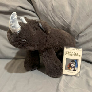 long rhino stuffed animal with Les Miserable cassette tape